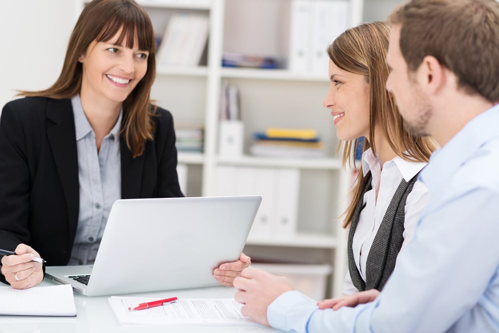 Young couple sitting in an office talking to a woman broker or investment adviser Young couple sitting in an office talking to a woman broker or investment adviser
